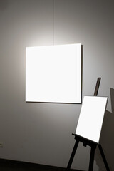 Blank picture frames on grey wall with glowing lamp, mock up