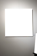 Blank picture frames on grey wall with glowing lamp, mock up