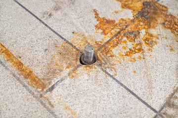 a protruding old bolt from an anchor in the tiled floor. repair and reconstruction and renovation.