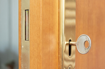 Wooden door with a gold lock and key