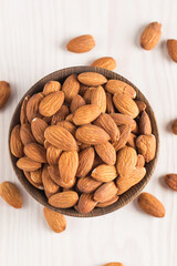 Raw peeled almonds in brown bowl