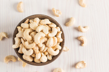 Organic roasted cashew nuts in a wooden bowl. Top view. 