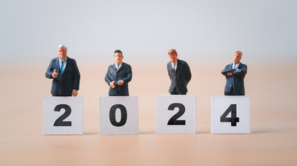 Businessmen miniature figure standing with 2024 for preparation of new year and start new business...