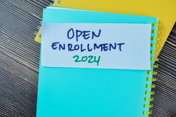 Concept of Open Enrollment 2024 write on sticky notes isolated on Wooden Table.