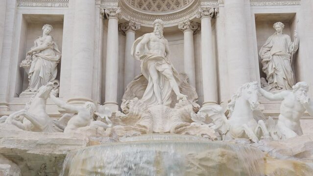 The Fontana di Trevi, baroque landmark located in centre of Rome, Italy. Famous tourist attraction in Roma, Italia. Trevi Fountain and Sculptures in sunny day. Europe travel destination background.