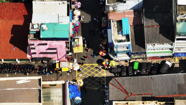 Detailed birds eye shot of people walking in city streets. High angle view of narrow aisles with markets in busy commercial area. Colombo, Sri Lanka
