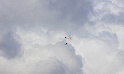 Parachutist silhouette against dramatic cloud sky. Sport, hobby background