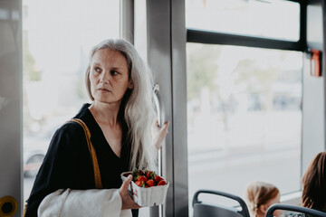 Portrait of beautiful woman in middle age with gray hair traveling by bus.