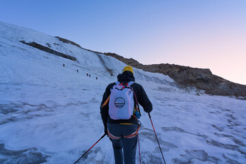 Mountaineers climbing Gran Paradiso glacier to the summit of the mountain at sunrise. Gran Paradiso...