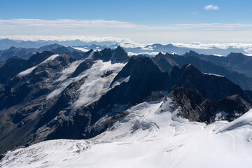 Fototapeta na wymiar View from Gran Paradiso (National Park) mountain summit: glaciers of the massif and high rocky peaks. Mountains landscape.