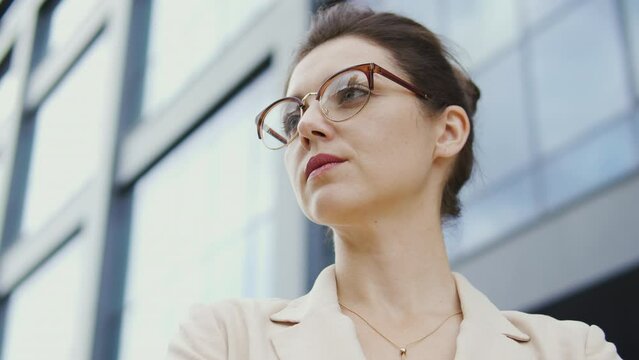 Self-confident woman lawyer in elegant blazer standing near court building with folded on chest hands, ready to fight injustice and corruption, to protect the wrongly convicted