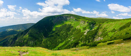 Giant Mountains, mountain panorama from the hiking trail to the top of Sniezka. View of the vast mountain slopes and trails on a sunny summer day.