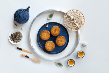 Flat lay Mid-autumn festival food and drinks - mooncake and tea set on white background.