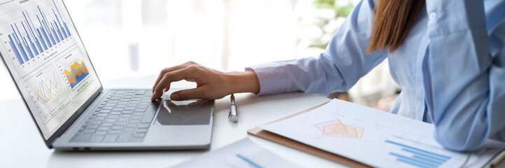 Asian businesswoman sitting and thinking analyze financial reports Business growth using laptop computer and documents, graphs, charts, investment calculators. Office business plan