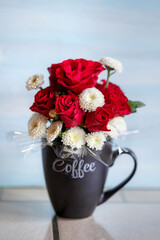 Bouquet of red roses in a coffee cup