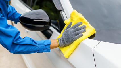 Man cleaning the car with a clean cloth, washing the car, wiping the car, polishing the car, wiping dust