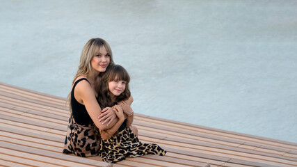 Mom hugs little daughter for a walk