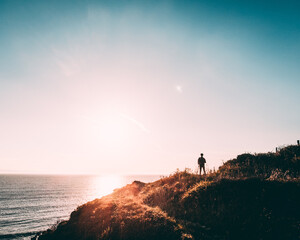 silhouette of a man on a cliff