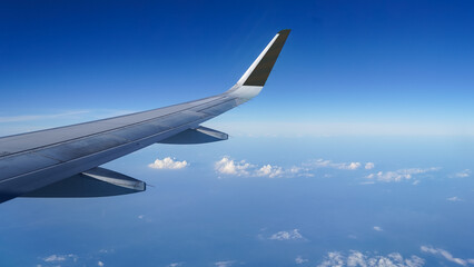 Airplane wing on a background of blue sky flight time