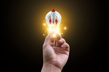 Businessman holding a light bulb with a rising rocket. New concept. Innovation technology. and...