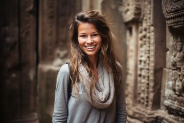 Naklejka premium Lifestyle portrait photography of a grinning girl in her 30s wearing a long-sleeved thermal undershirt at the angkor wat in siem reap cambodia. With generative AI technology