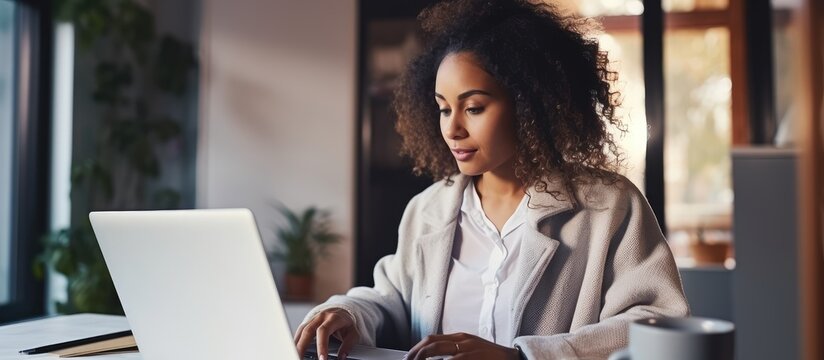 Biracial woman on laptop working remotely with copy space on screen