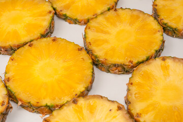 Pineapple juicy yellow slices on a white background.