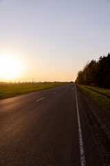 paved road at dusk during sunset, empty road