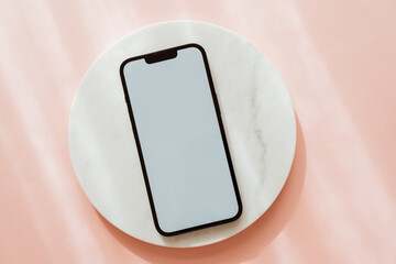 White blank path screen mobile phone with mockup copy space on white marble podium on pink background with shadows