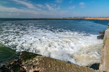 Waste water is poured into the estuary, dirty foam. Ecological problems of the reservoir. Hadzhibey estuary, Ukraine