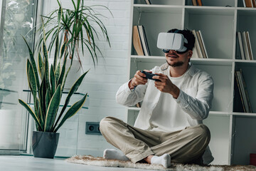 young male at home with virtual reality glasses and joystick