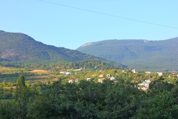 A beautiful mountain landscape with a small flowering green village lost among the rocks