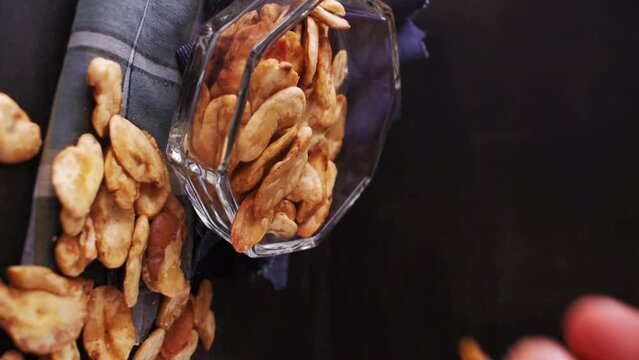 Vertical video of man taking some toast avas from glass pot on black background