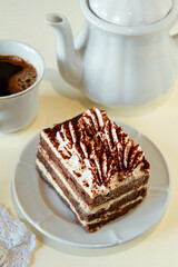 Traditional Italian dessert tiramisu on a white plate.
