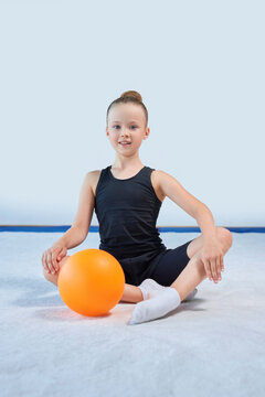 Image of a little girl with a ball in the gym. Gymnastics concept.