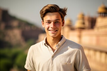 Close-up portrait photography of a happy boy in his 20s wearing a classy polo shirt at the amber fort in jaipur india. With generative AI technology