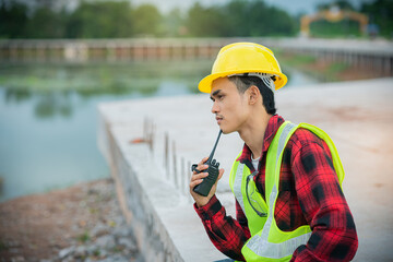 Obraz premium Engineer wearing a yellow hat Thinking about analyzing work