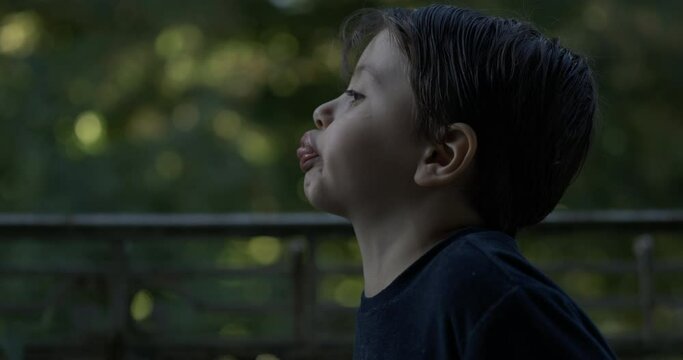 Little boy spitting in super slow motion 1000 fps, doing funny grimaces with mouth