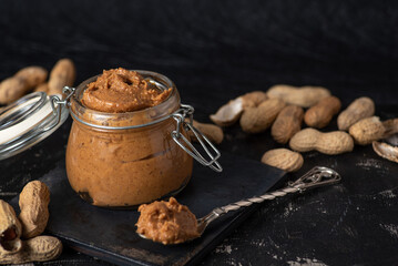 Peanut butter in a jar and peanuts in the shell