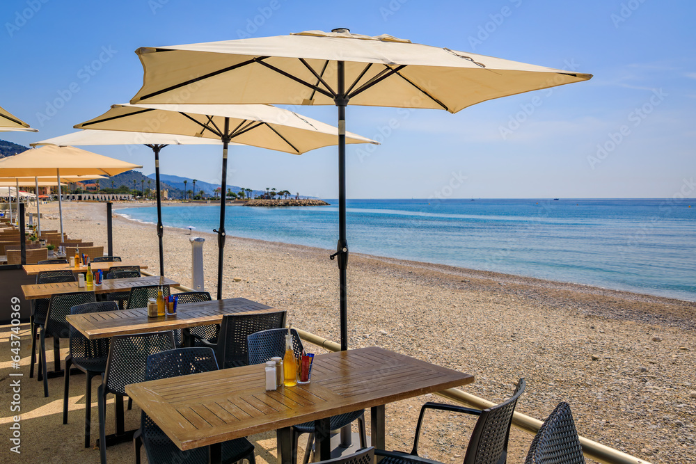 Wall mural seaside promenade with outdoor restaurant tables along the mediterranean sea in the old town of ment