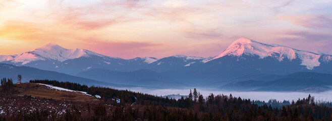 Early morning spring Carpathian mountains plateau landscape with snow-covered ridge tops in far, Ukraine.