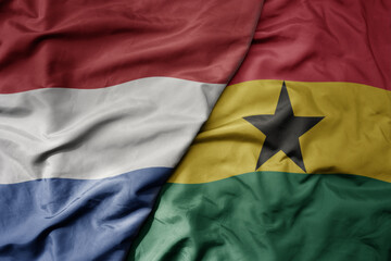 big waving national colorful flag of netherlands and national flag of ghana . - obrazy, fototapety, plakaty