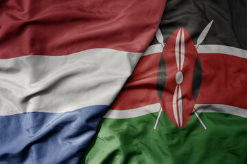 big waving national colorful flag of netherlands and national flag of kenya .