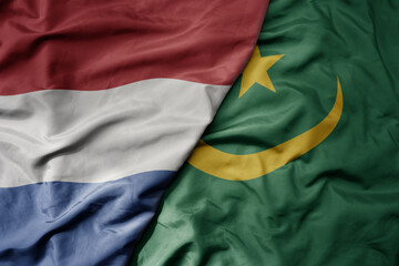 Obraz premium big waving national colorful flag of netherlands and national flag of mauritania .