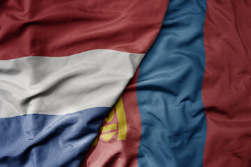 big waving national colorful flag of netherlands and national flag of mongolia .