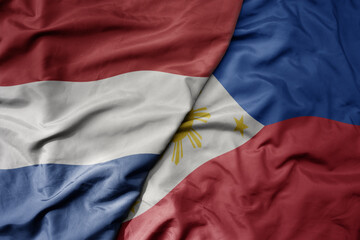 big waving national colorful flag of netherlands and national flag of philippines .