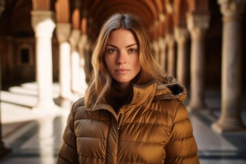 Conceptual portrait photography of a glad girl in her 30s wearing a durable down jacket at the alhambra in granada spain. With generative AI technology