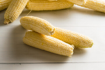 Delicious, sweet white corn on a light table close-up