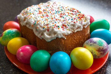 festive Easter cake, decorated with white fondant, painted multi-colored eggs lie around