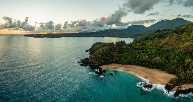 Aerial panoramic image off the coast over Lumaha'i beach on Hawaiian island of Kauai with Na Pali mountains behind. Taken at dawn